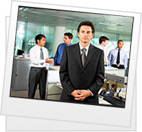 Professional man stands in office with colleagues working in the background